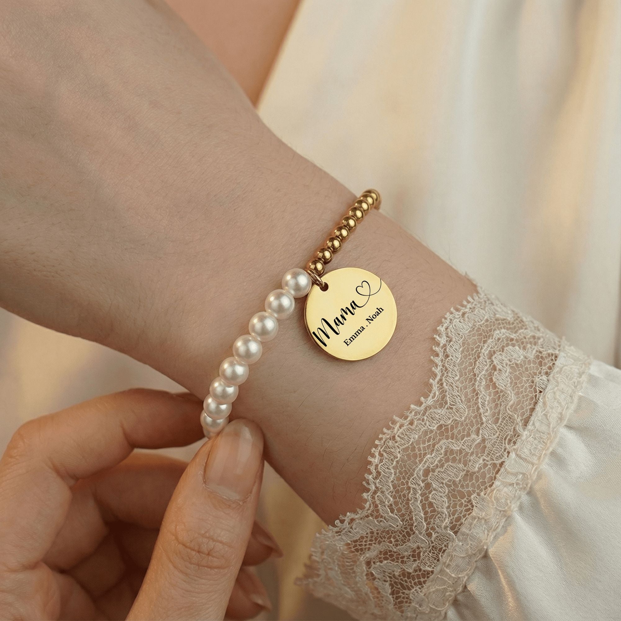 Perlenarmband mit 18k vergoldetem Anhänger graviert mit Mama, Emma und Noah – am Handgelenk getragen