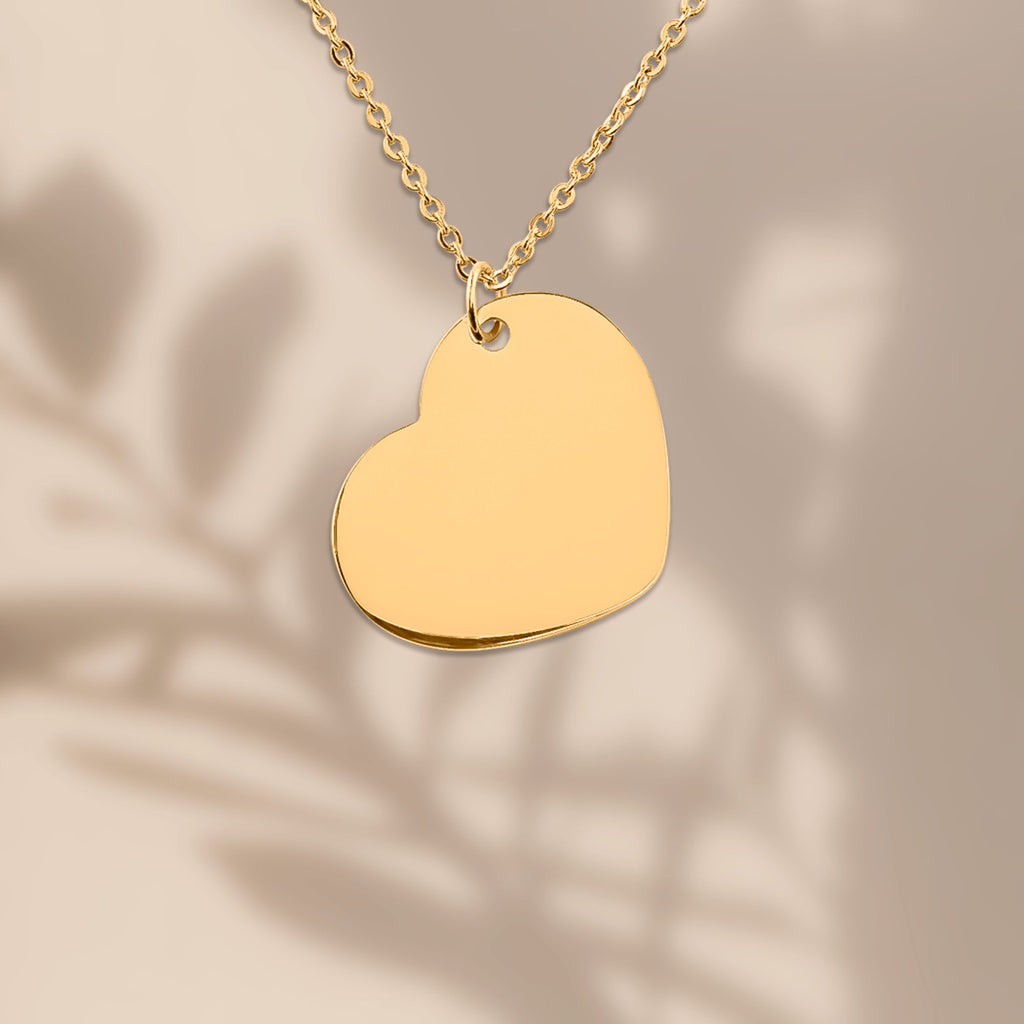Herzkette Gold Nahaufnahme – Herzanhänger mit Pflanzen-Schatten im Hintergrund, Lifestyle-Foto